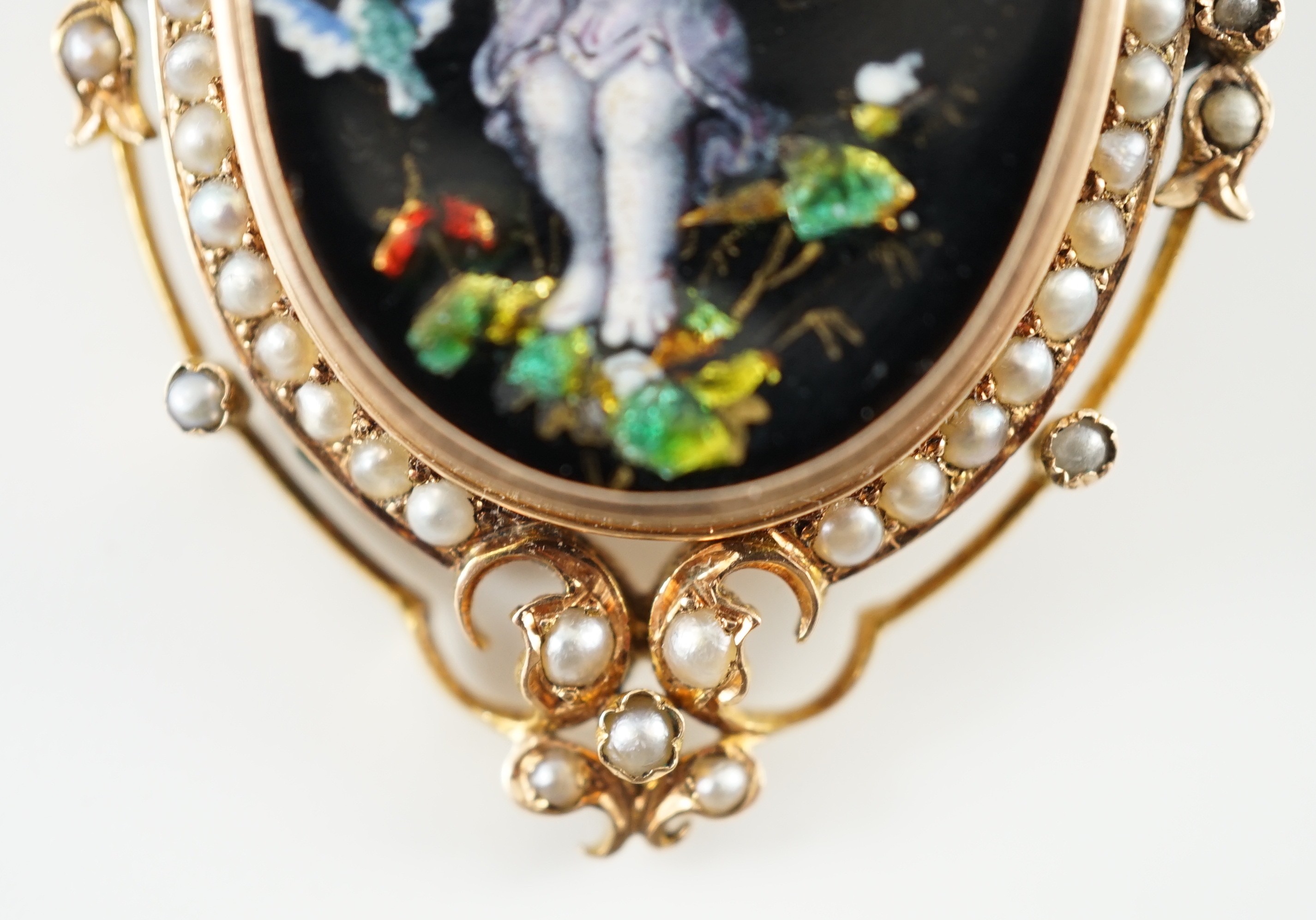 A Victorian oval gold and enamel pendant/brooch, painted with a cherub offering cherries to a dove, within a black and split pearl outer border